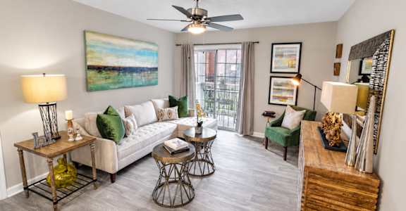 A living room with a white couch, a wooden coffee table, and a painting on the wall.