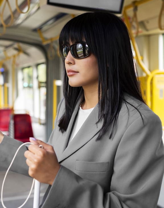 Woman Wearing Grey Suit and Sunglasses while on Bus