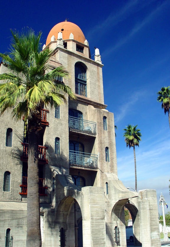 an old building with a dome and palm trees