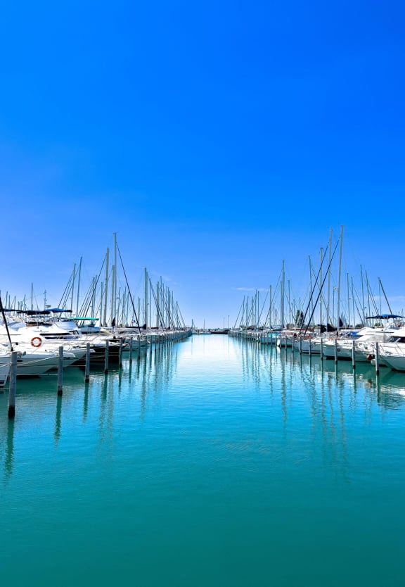 boats docked in a harbor under a blue sky