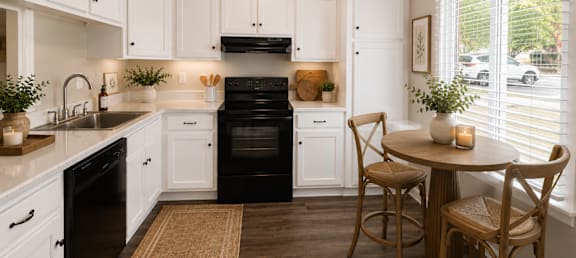 A kitchen with white cabinets and black appliances.