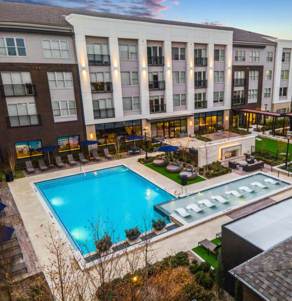 an overhead view of a swimming pool and a hotel with a large building