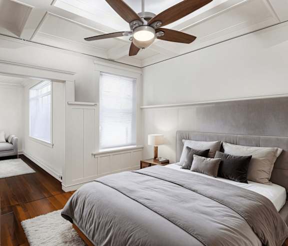 A bedroom with a large bed and a ceiling fan. at Midtown Apartments, Oregon