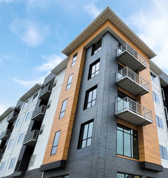a tall apartment building with balconies and a blue skyat First Street Lofts in Downtown Bismarck, Bismarck, ND, 58506