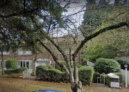 a large brick house with trees in front of it