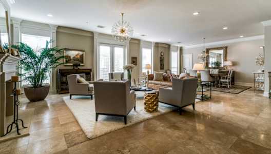 A living room with a large rug and a chandelier.