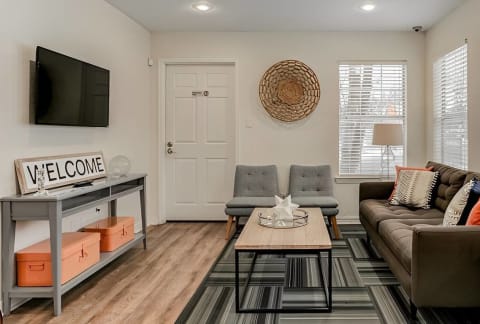 a living room with a couch and a tv at Aspen Landing, Kansas City, MO