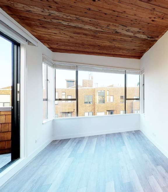 an empty room with white walls and a wooden ceiling