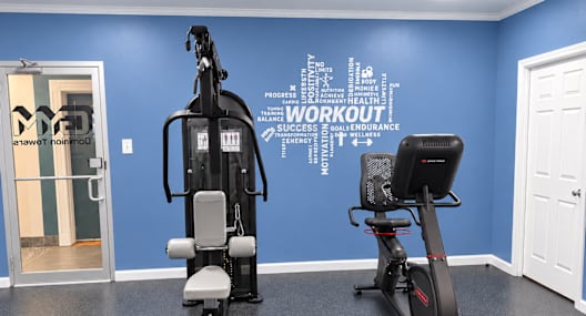 A gym room with a blue wall and a word cloud that says "workout".