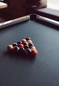 A pool table with a group of balls in a triangle formation.