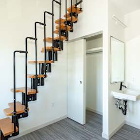 A white bathroom with a black metal staircase. at Society 62 Apartments, Portland