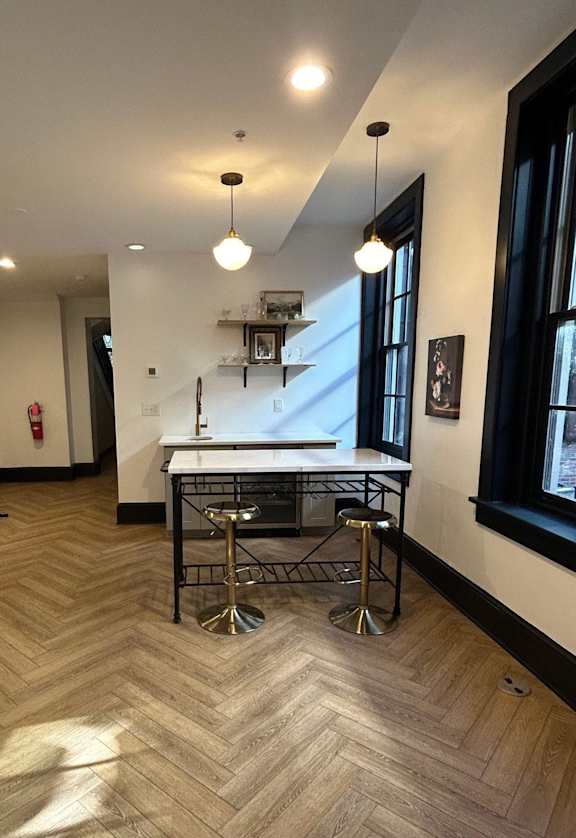 a dining area with a table and chairs in a room with a large window
