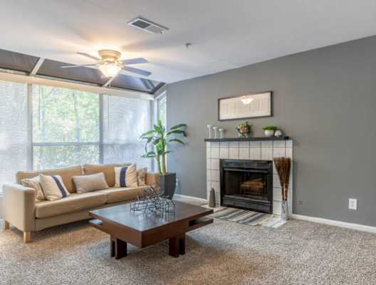 a living room with a fireplace and a large window