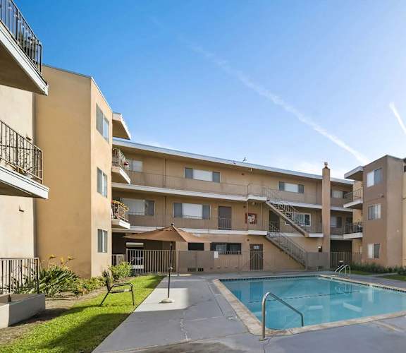 A large apartment complex with a pool in the middle.