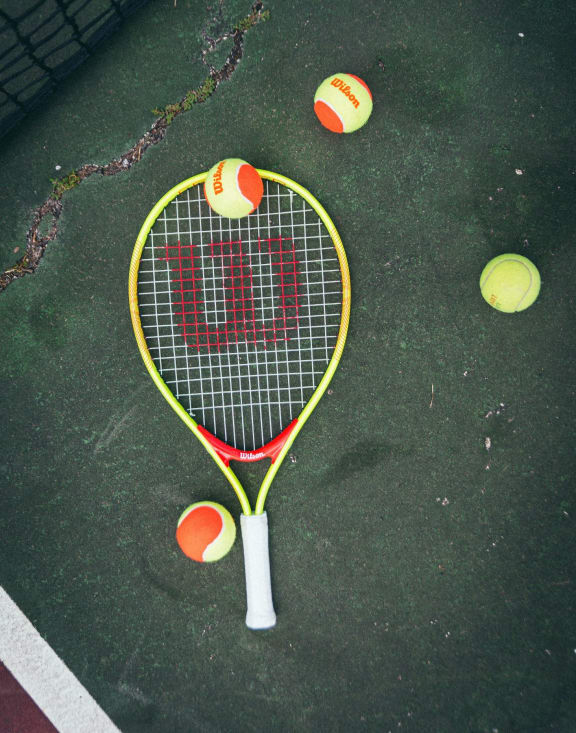 a tennis racket and tennis balls on a court