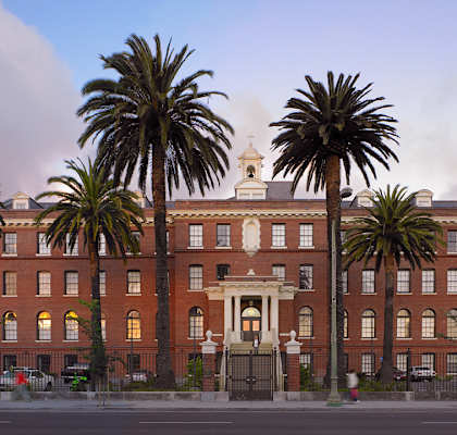 a large brick building with palm trees in front of it