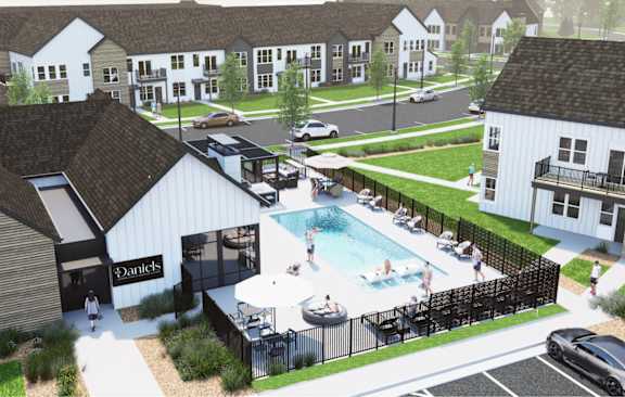 A pool area with a black fence and a white building with the name Daniels on it.