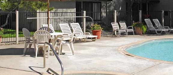 Pool view with seating Clubhouse with seating and fireplace  l Pepperwood Apartments in Davis CA