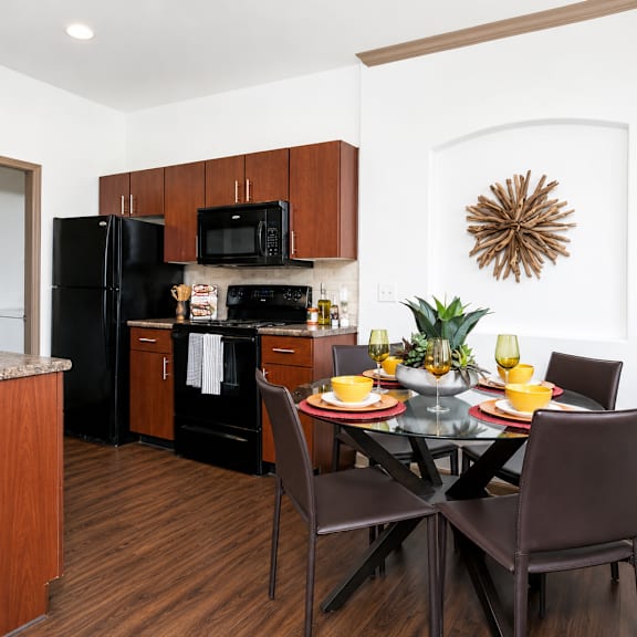 A modern kitchen with a dining table set for two.