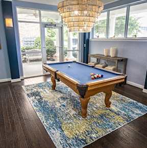 A pool table in a room with a view outside.