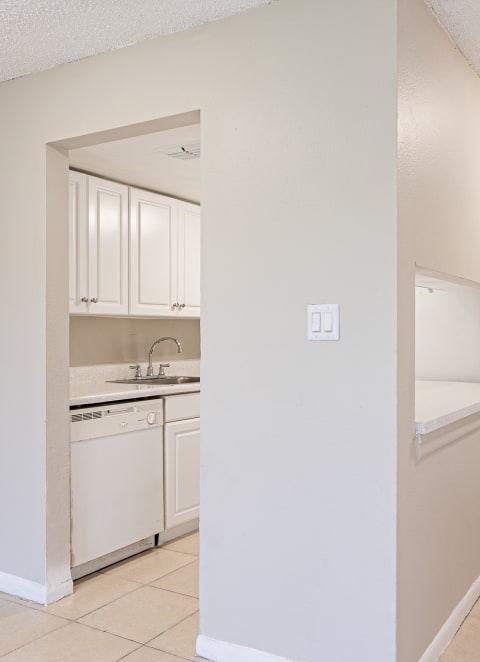  a kitchen with white cabinets and a white door at Del Rio Apartment
