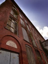 Corner of Converse Mill Lofts before restoration, a historic 19th-century textile mill in Spartanburg, now a residential apartment.