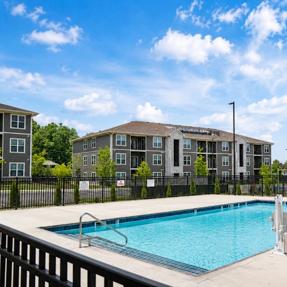 A swimming pool in front of apartment buildings.