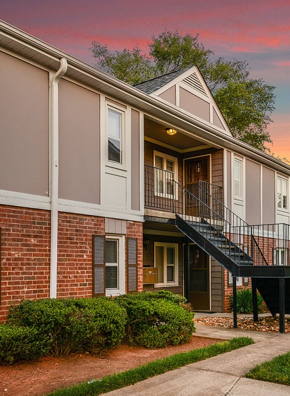 an apartment building with stairs and a sunset in the background at Randolph Park, Charlotte