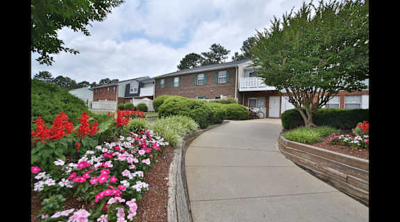 a sidewalk with colorful flowers in front of a building