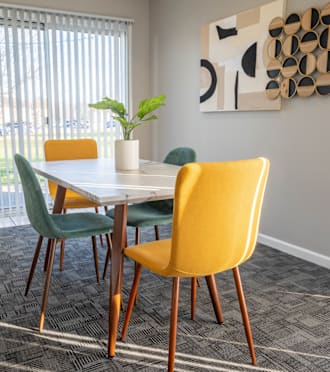 A dining room with a table, chairs and a plant at Creekside Square Apartments, Indianapolis, IN 46254.