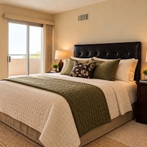 A bedroom with a large bed and a painting on the wall.