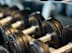 A set of dumbbells are lined up on a rack.