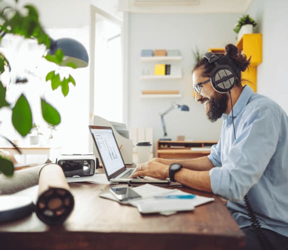 a man sitting at a desk with headphones on and working on a laptop at Scottsdale Hayden Townhomes, Arizona, 85257