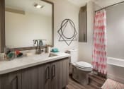 Thumbnail 25 of 27 - Bathroom with sink, large mirror, toilet, and bathtub