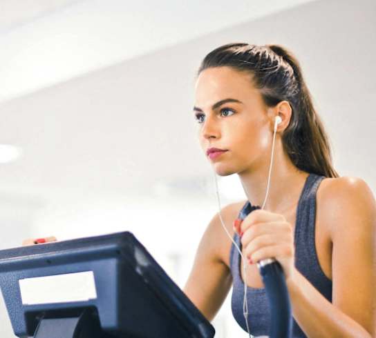 A woman is working out on a stationary bike.
