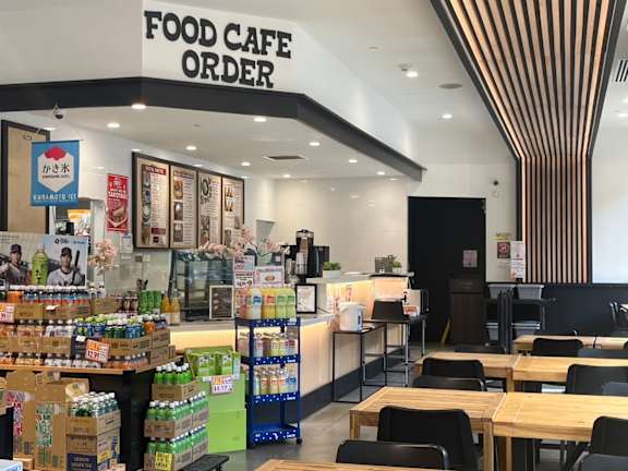 A food cafe with a variety of drinks and foods on display.