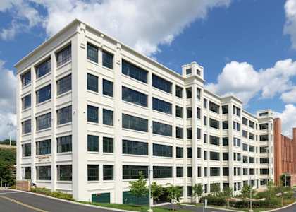 a large white building with a street in front of it at Montgomery Mill Apartments in Windsor Locks, CT