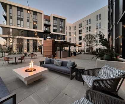 a rendering of a patio with furniture and a fire pit