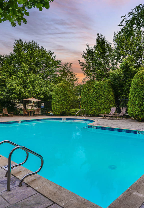 a swimming pool in a backyard with trees and a house at Residences at Westborough Station, Massachusetts, 01581