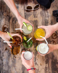 Group of Friends Toasting with Drinks Over Table