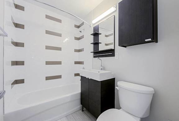 A white toilet sits next to a sink in a bathroom.at 107 Redpath, Toronto California