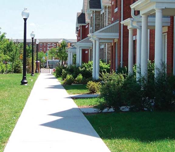 A long white pathway leads the eye through a grassy area and up a hill.