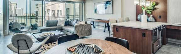 A modern living room with a large wooden table and comfortable seating.