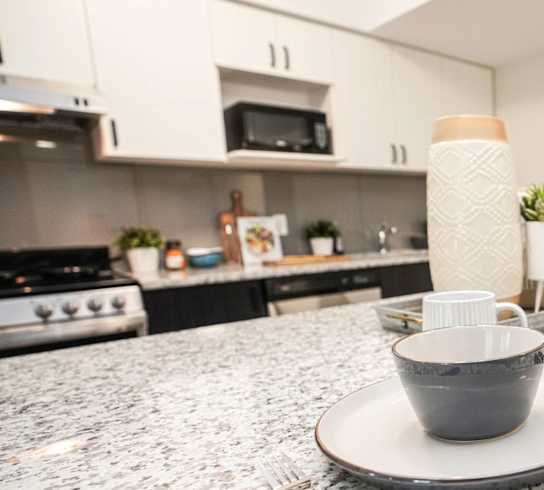 A kitchen counter with a cup and a fork on it.