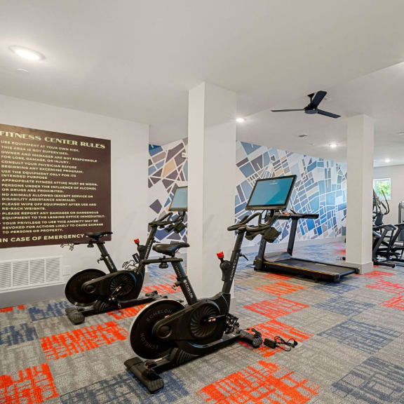 a gym with weights and cardio equipment in a room with a sign on the wall