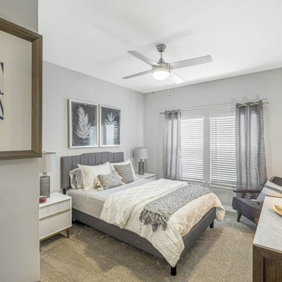 an empty bedroom with a bed and a ceiling fan