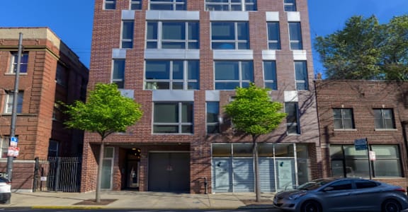 A modern brick building with a black car parked in front.