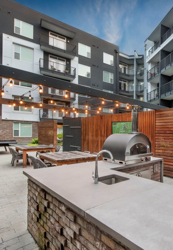 an outdoor patio with a bbq grill and an apartment building in the background at Glenn Perimeter, Georgia, 30328