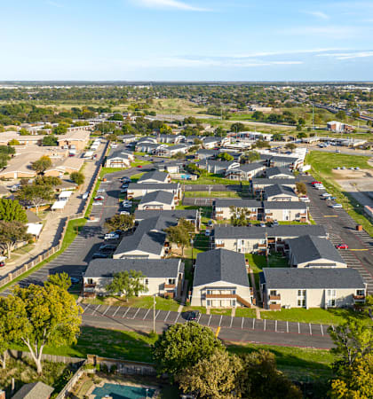A bird's eye view of a suburban area with a mix of residential and commercial buildings.