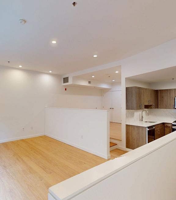 A large empty room with wooden floors and white walls.